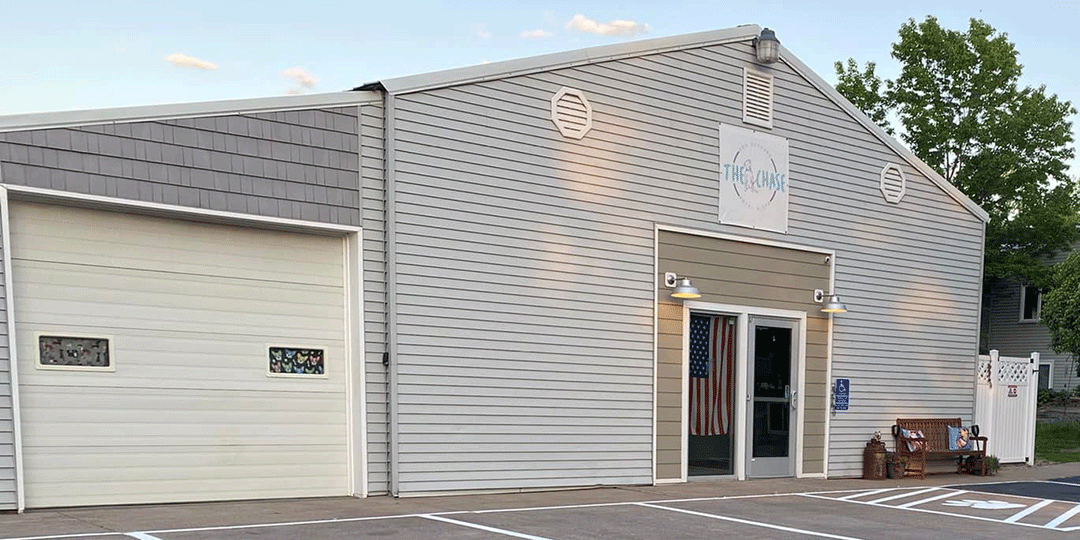 The front entrance of The Chase Dog Club with a handicap parking spot.	